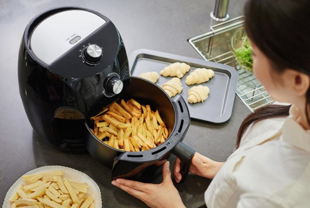 A woman uses an air fryer