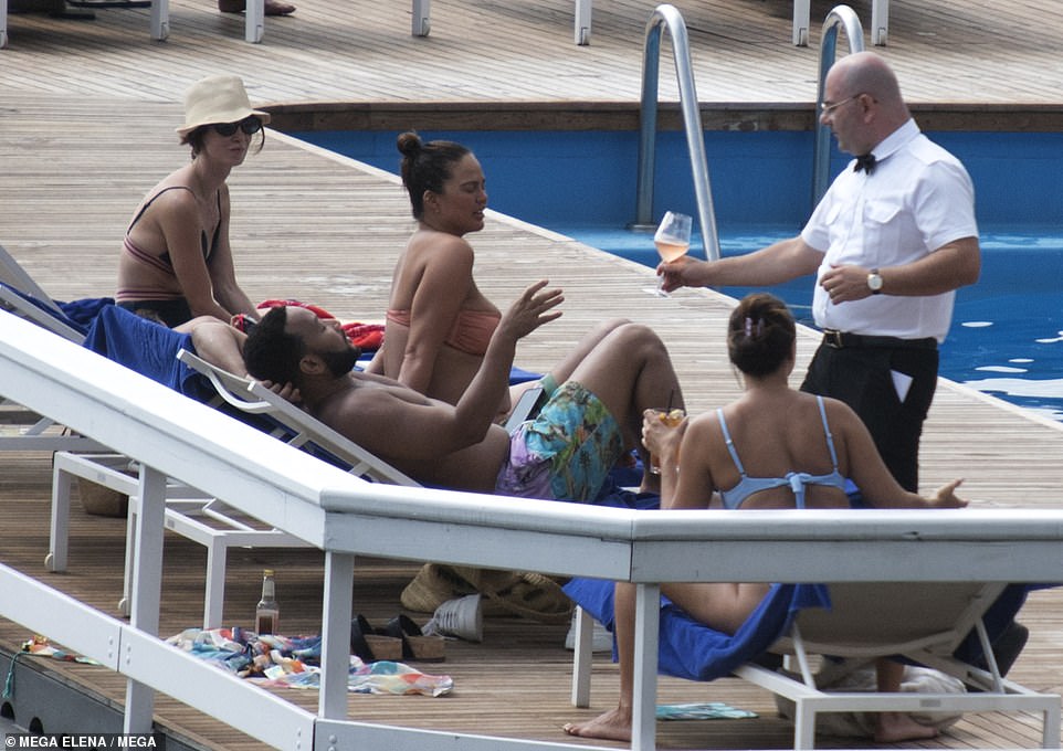 Holiday mode: A waiter delivered John a glass of rosé wine to enjoy outside