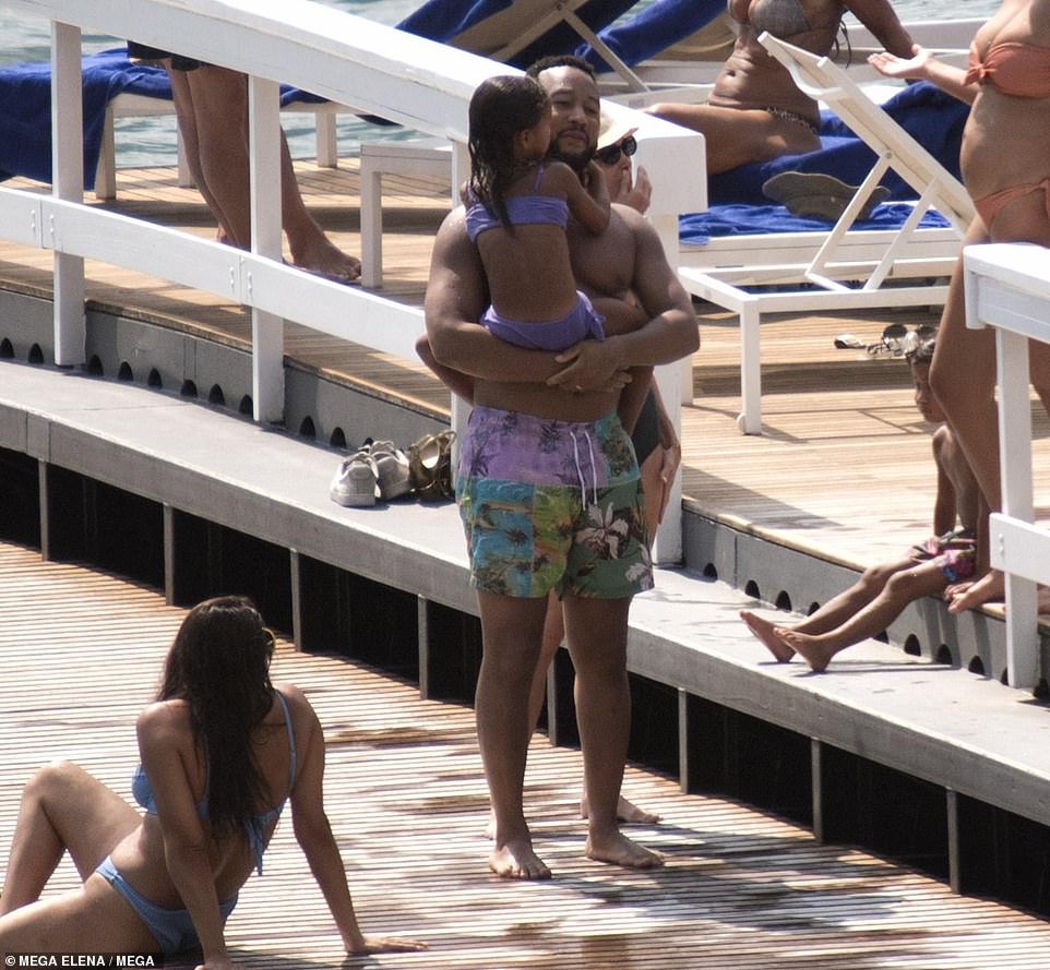 Helping hand: John carried Luna to the water as she prepared to get a life jacket on