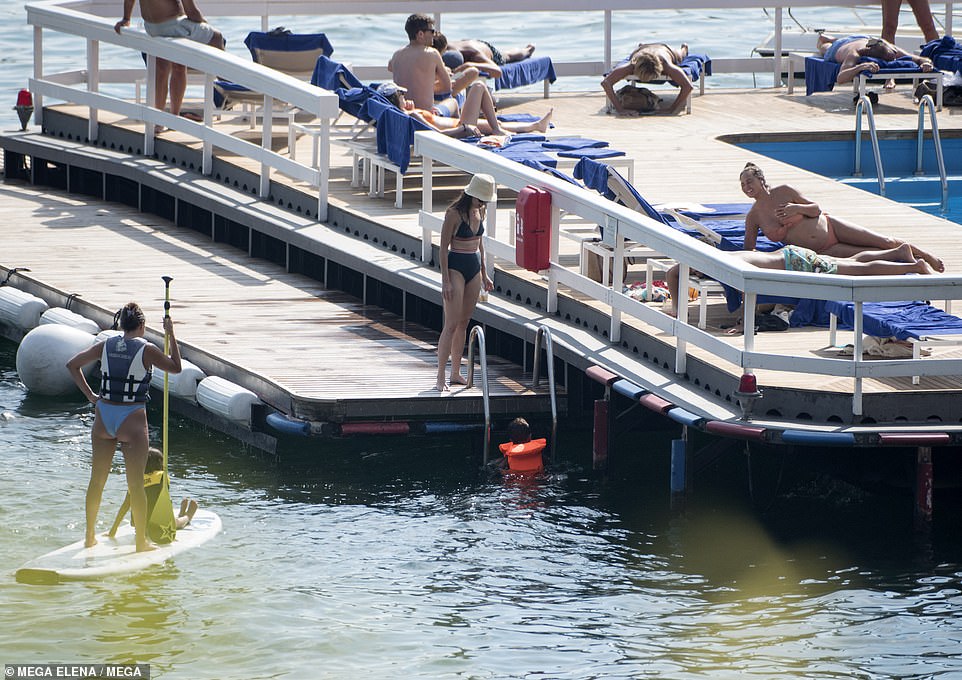 Keeping an eye: The couple watched on from the side as their children had fun in the water