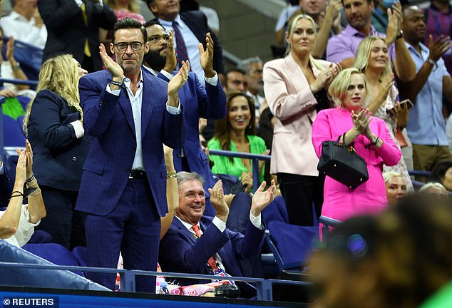 Hugh looked dapper in a navy tuxedo and white buttoned shirt as he watched the tennis tournament from the stand