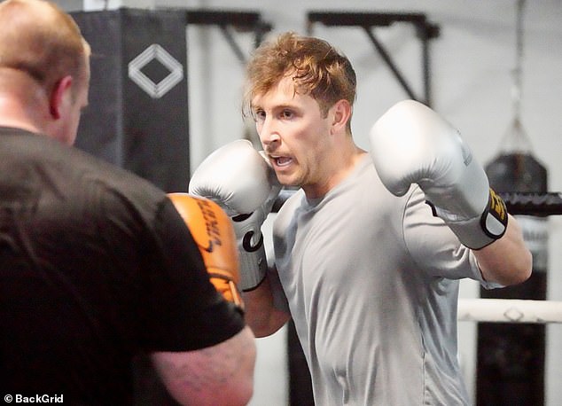 Wearing a grey shirt, black shorts, black sneakers and a set of silver gloves, the reality star had a look of steely determination on his face as he started off against a larger man