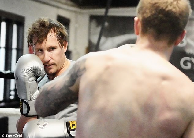 Daniel looked determined as he sparred with a shirtless tattooed man