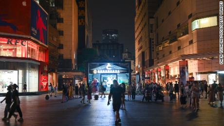 People visit the Taikoo Li shopping complex as lights are partially turned off to conserve energy on August 18, 2022 in Chengdu, Sichuan Province of China. 