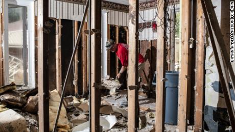 A friend helps tear out drywall at Sam Quillen&#39;s damaged property in Fleming-Neon, Kentucky.