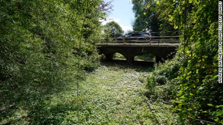 A car passes over a bridge over a dried up river bed where the River Thames usually flows, near Kemble in Gloucestershire.