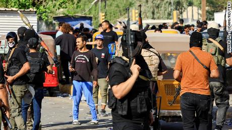 Fighters loyal to al-Sadr gather during clashes with Iraqi security forces near Baghdad&#39;s Green Zone on Monday.