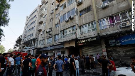 Palestinians gather next to the site of an Israeli strike in Gaza City on Friday.