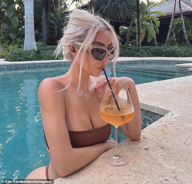 Kim Kardashian shows off cleavage as she plugs Beats Fit Pro collection in poolside snapshots