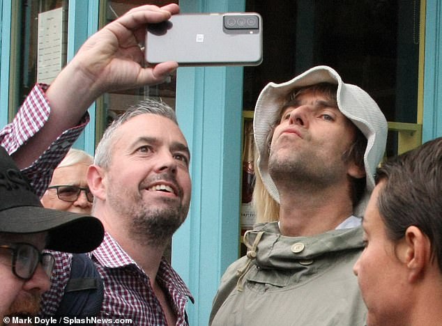 Liam Gallagher puts on a very animated display as he playfully poses for selfies with fans in Dublin