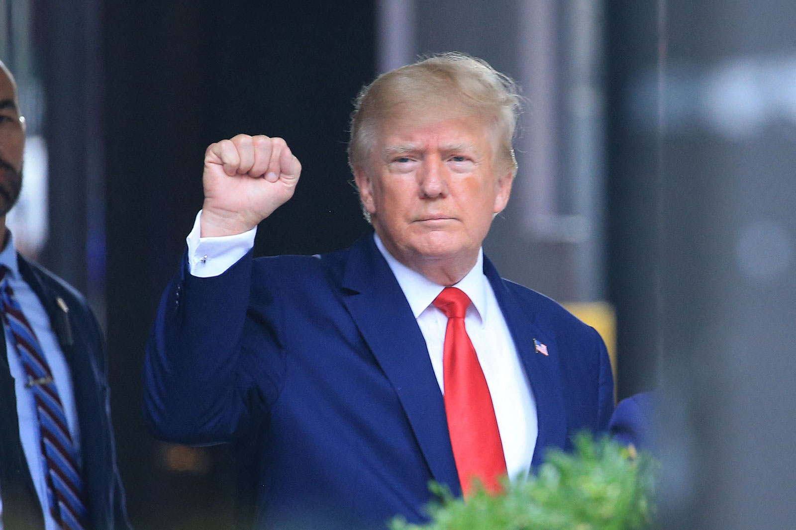 Former President Donald Trump raises his fist while walking to a vehicle outside of Trump Tower in New York on August 10.