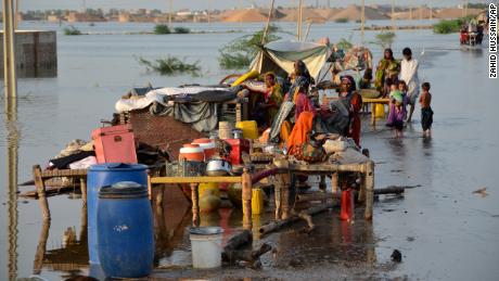 Families sit near their belongings inundated by flood waters in Pakistan&#39;s southwestern Balochistan province on August 28, 2022.