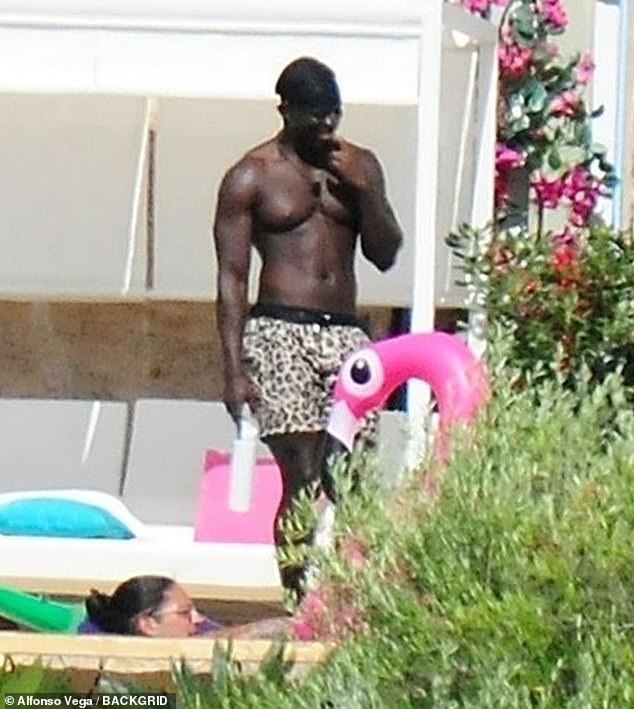 One of the handsome hunks from the upcoming season is pictured strolling next to the pool with a water bottle in hand