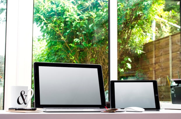 Home office space with graphic designers desk with laptop near a window.