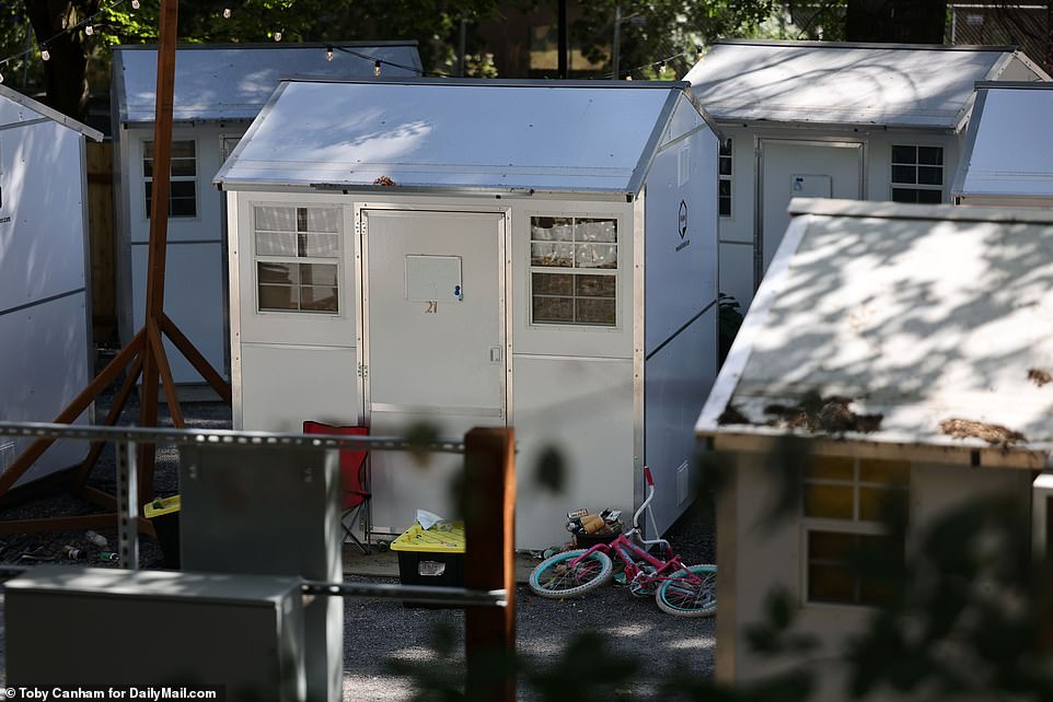 Tiny white structures are crowded together in a lot at one of the homeless encampment sites in Portland