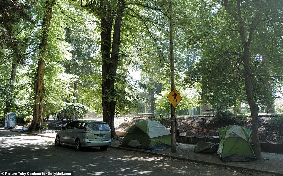 Tents are pitched alongside a street not far from a school. Portland Mayor Ted Wheeler plans to ban encampments within 150 feet of school buildings and along routes where students are likely to be walking to school