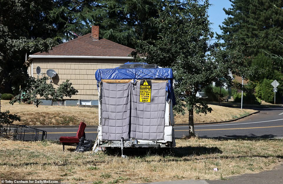 A trailer covered with a tarp on North Ida Avenue. Residents say grassy areas are popular spots for homeless to set up camp