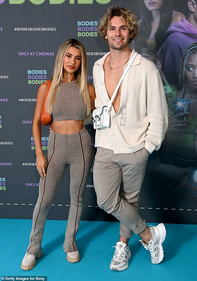 Pals: The beauty seemed in high spirits as she posed alongside another ITV2 star Joseph Garratt who rocked a half unbuttoned cream shirt with a pair of grey trousers