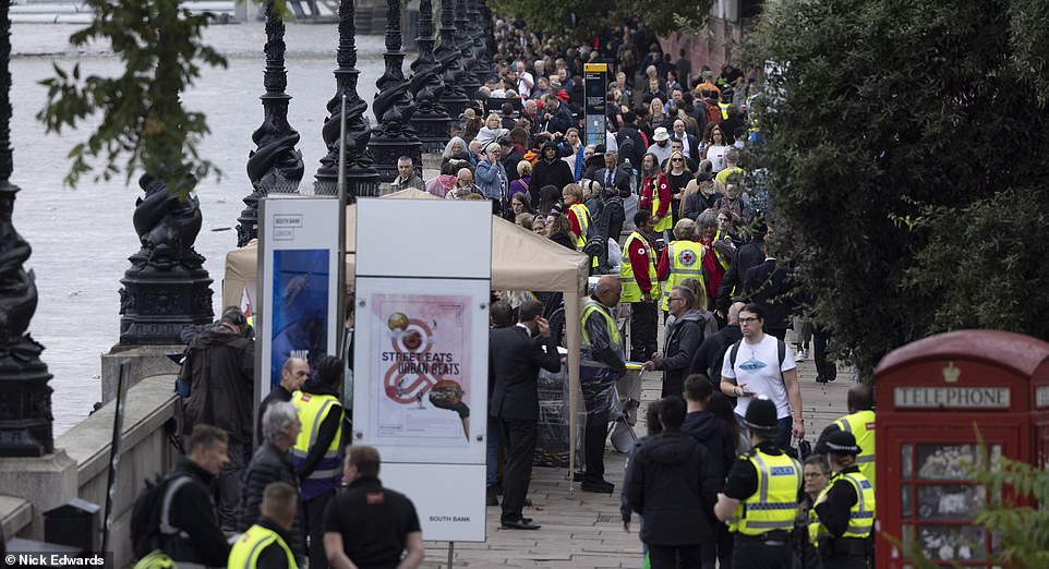 Mourners queue along the Thames opposite the Houses of Parliament to see the Queen's coffin