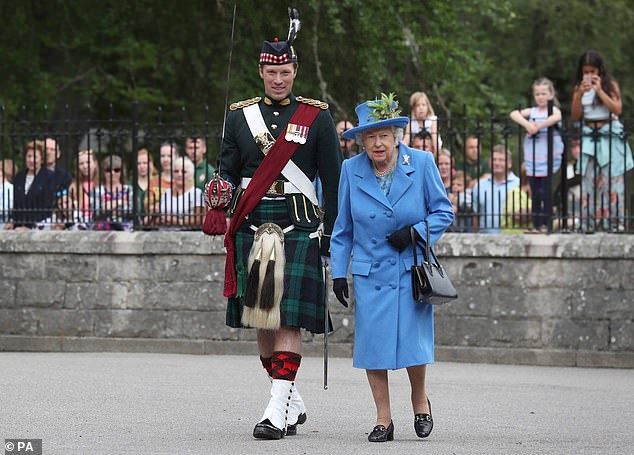 Major Thompson (pictured left) cracked a smile as he walked with the Queen through the gates of Balmoral Castle earlier this year, before the monarch's death