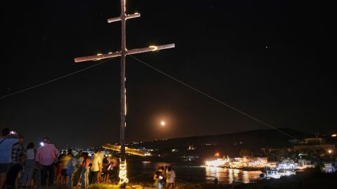 Christian Greek Orthodox worshippers gather on a cliff around a lit wooden crucifix to celebrate the Exaltation of the Holy Cross in the coastal town of Anfeh, some 70 kilometers (43 miles) north of the Lebanese capital, Beirut, on Tuesday.  