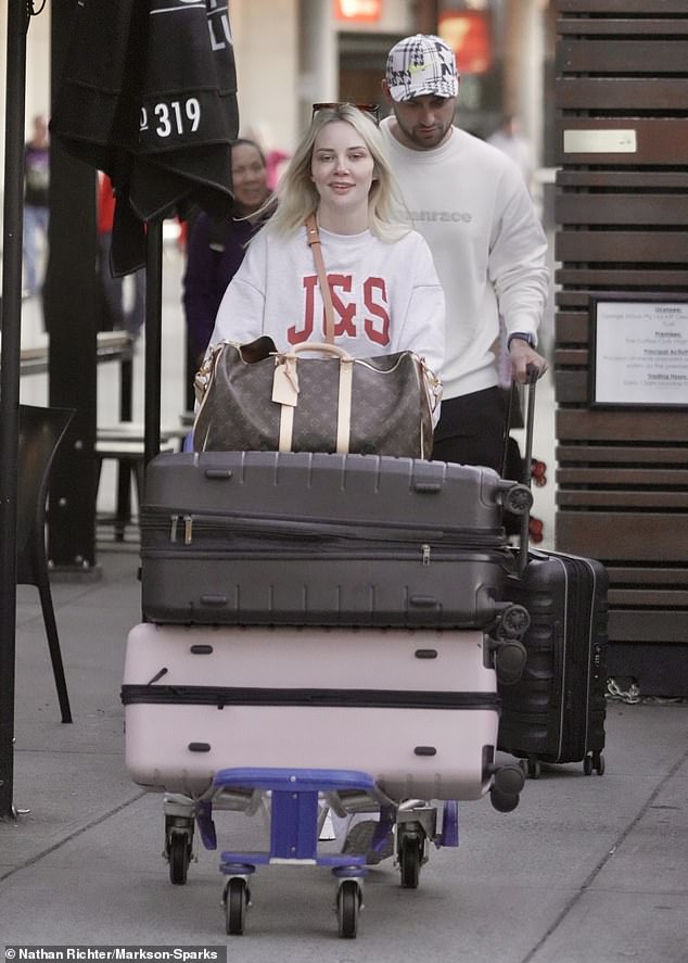 The couple pushed a trolley stacked with suitcases outside the airport