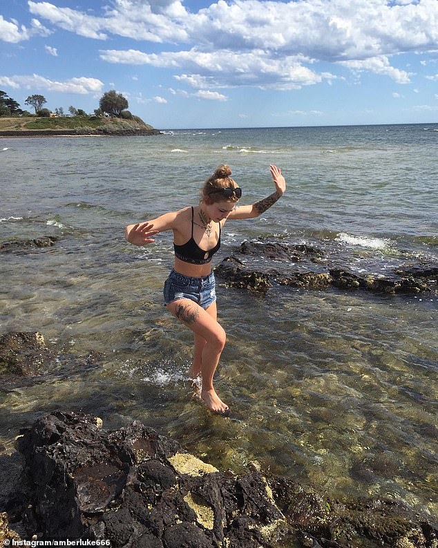 A young Amber frolics on the beach shortly after getting her first few tattoos