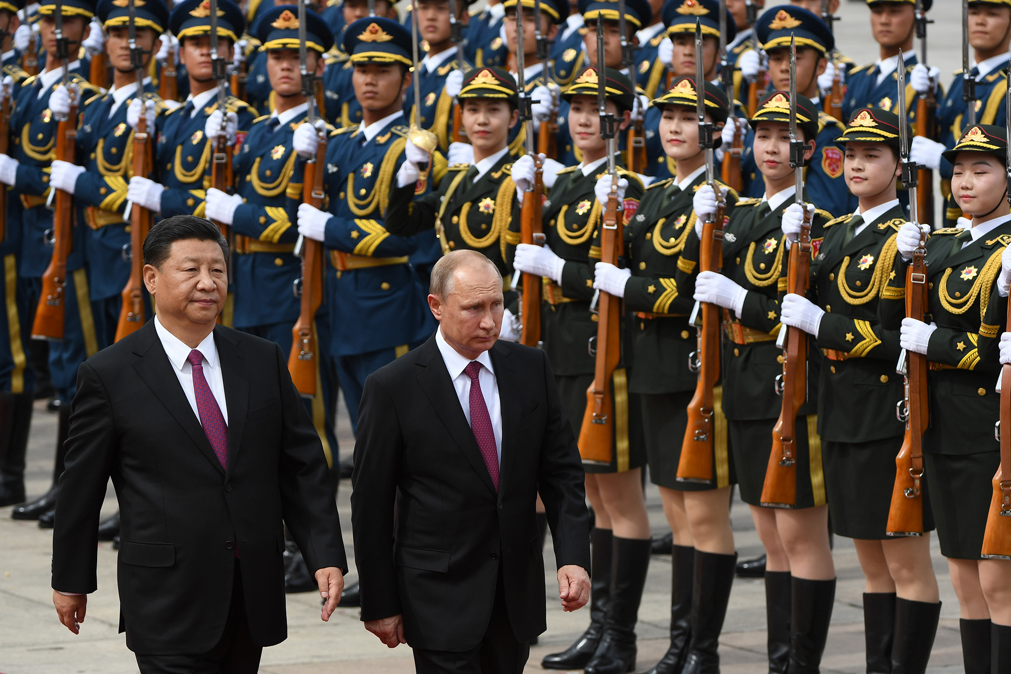 Russian President Vladimir Putin reviews a military honor guard with Chinese leader Xi Jinping during a welcoming ceremony outside the Great Hall of the People in Beijing on June 8, 2018. 