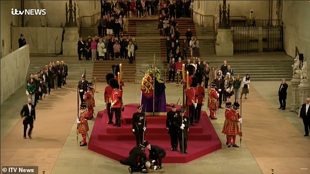 Two police officers quickly rushed to help the man as the remaining guards continued to hold vigil next to the coffin