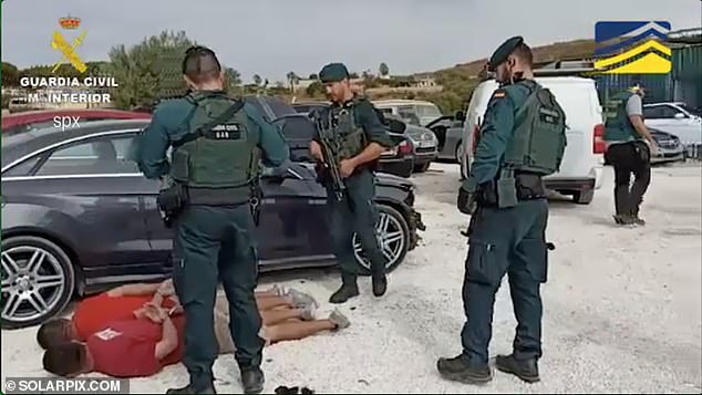 Police are pictured carrying out a search at a vehicle storage facility where drugs were found in the cars