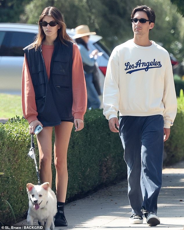 Casual: The model wore a long sleeve dusty rose sweatshirt, an oversized black utility vest and black shoes. Her friend appeared comfortable in a white and blue Los Angeles sweatshirt, blue pants and sneakers