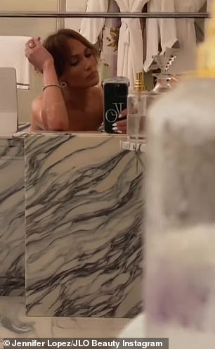 Happy: As the video came to an end, Jennifer was seen sending a quick smile to the camera in the reflection of the mirror