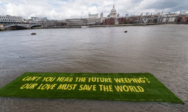 Grass banner art installation floats on the Thames in London