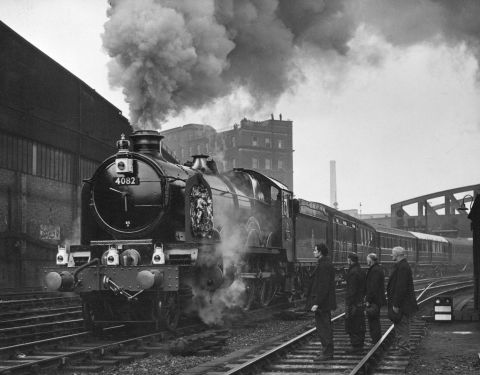 Railway workers pay their respects as the train carrying the King's coffin leaves Paddington station for Windsor. 