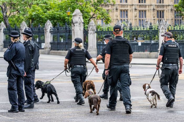 Police officers with sniffer dogs check the route ahead of the procession