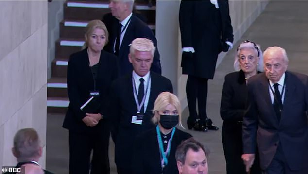 Attire: Phillip, 60, opted to wear a smart black suit and tie for the visit, with the presenter sporting a glum look on his face as he followed behind his co-star