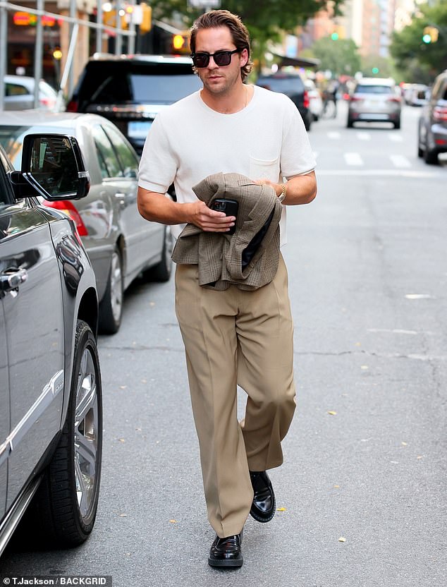 Casual: Ackerley kept it relatively casual in a white t-shirt and a pair of beige pants while spending time with his actress wife