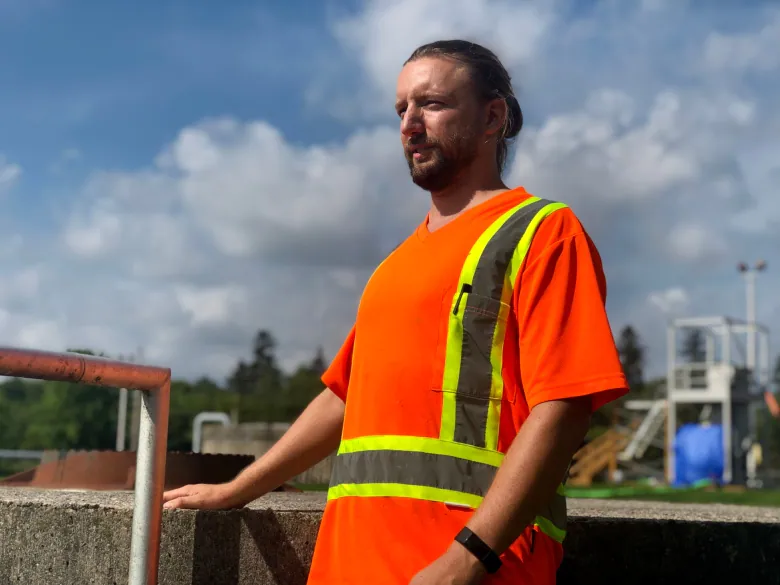 A man in a high-visibility vest puffs out his chest.