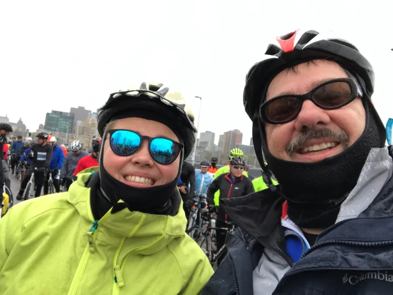 A woman and man wearing bike helmets smile for a selfie. 