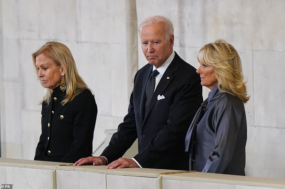 The president (center) and the first lady (right) view the coffin of Queen Elizabeth II as it lays in state on the catafalque in Westminster Hall on Sunday, September 18, 2022