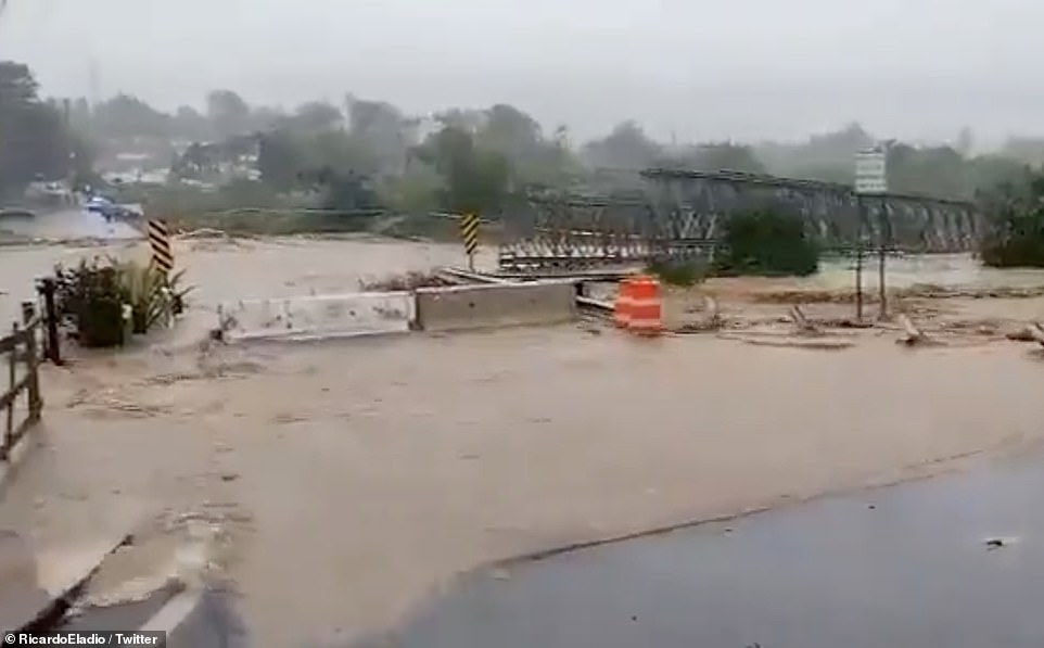 The massive metal bridge could be seen floating downstream as floods lifted it from its foundations on Sunday afternoon