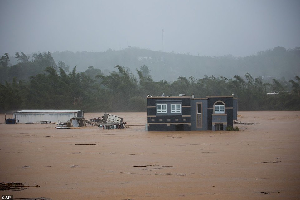 Three people inside a house await rescue from the floods caused by Hurricane Fiona in Cayey, Puerto Rico