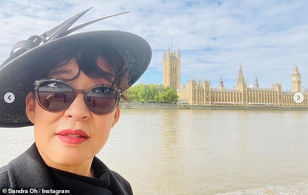 Historic day: Sandra sported a pair of sunglasses as she posed for a selfie in front of Westminster