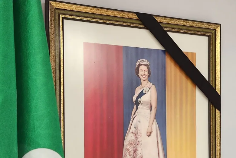 A picture of Queen Elizabeth II hangs in the mayor's office in Timmins next to the Franco-Ontarian flag with a black band across one corner.