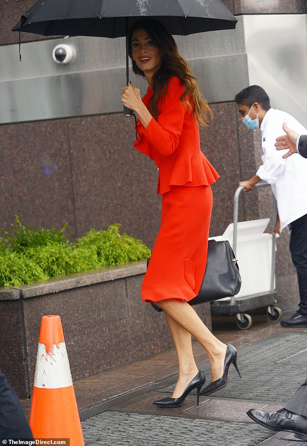 Can't rain on her parade! At one point, a bit of rain began to come down, prompting Amal to pull out her umbrella