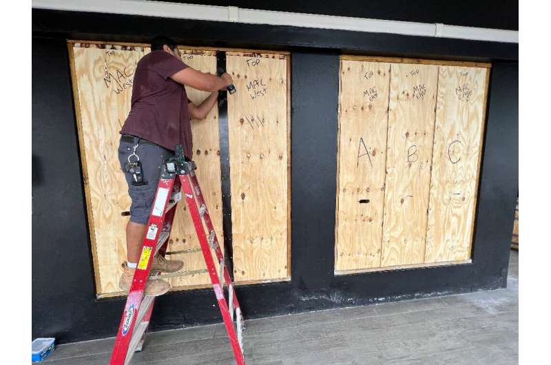 A man boards up a store in Hamilton, Bermuda on September 22, 2022 as Hurricane Fiona churns towards the Atlantic island