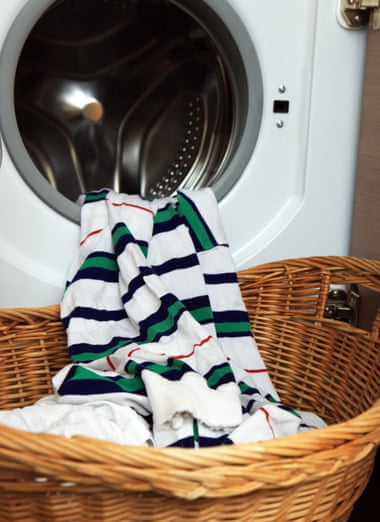 Clean washing coming out of a washing machine into a basket to be hung up