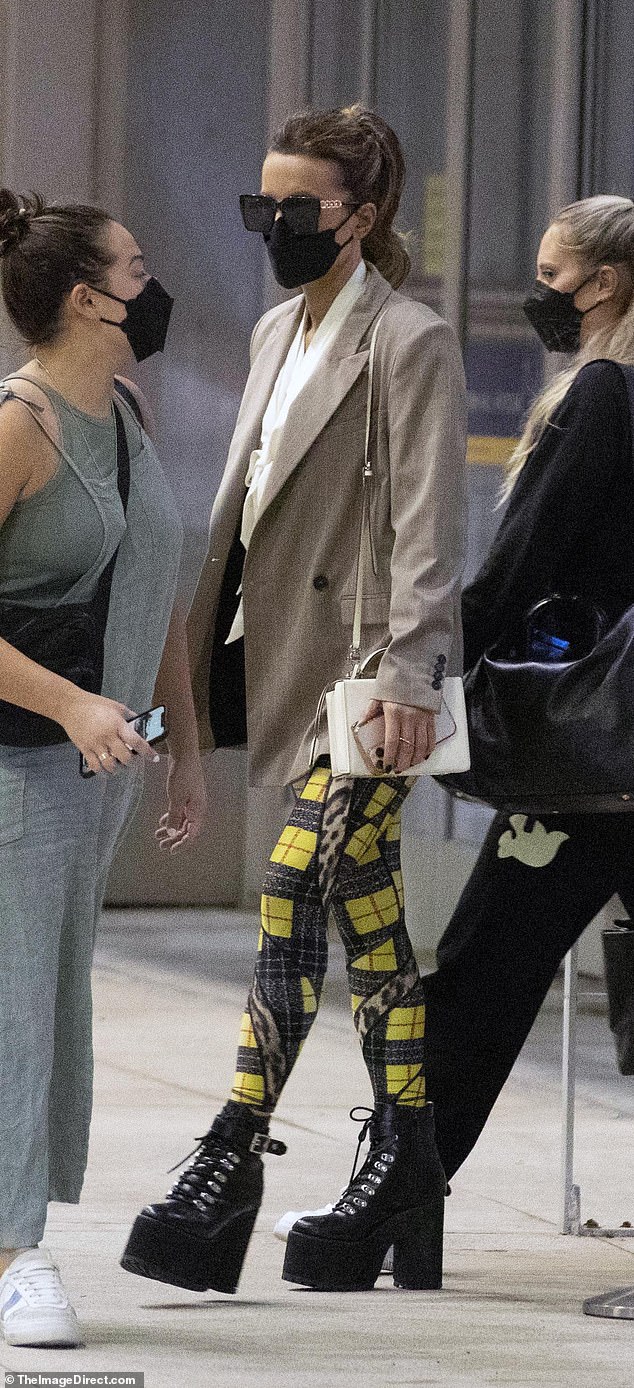 Kate Beckinsale looks quirky in checked leggings and towering platform heels at Toronto airport 