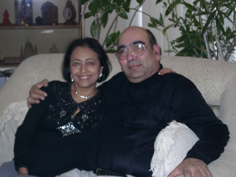 A smiling man and woman put their arms around each other.