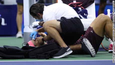 Nadal receives medical attention after accidentally hitting himself in the head with his racket.